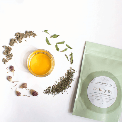 Alternate image of cup of tea surrounded by leaves and flowers from the tea and bag of tea