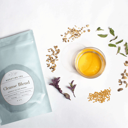 Alternate image of cup of tea surrounded by leaves and flowers from the tea and bag of tea