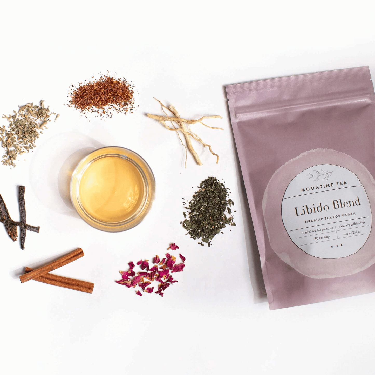 Alternate image of cup of tea surrounded by leaves and flowers from the tea and bag of tea